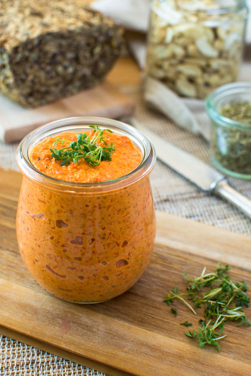 Weck-Glas gefüllt mit einem Paprika-Cashew-Aufstrich, der mit etwas Kresse dekoriert ist. 