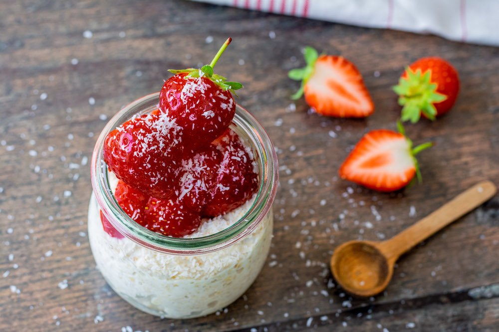 Joghurt Overnight Oats in einem Glas mit Erdbeeren dekoriert.