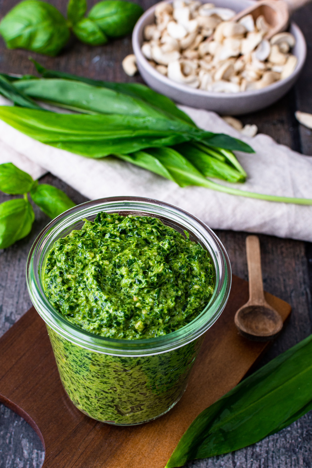 Bärlauch-Pesto im Glas, im Hintergrund Bärlauch und Cashewkerne