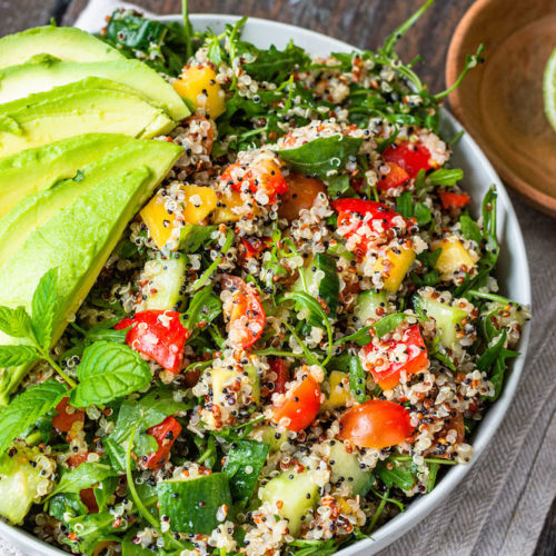 Quinoa-Salat in einer Schüssel mit aufgefächerter Avocado und Minze dekoriert