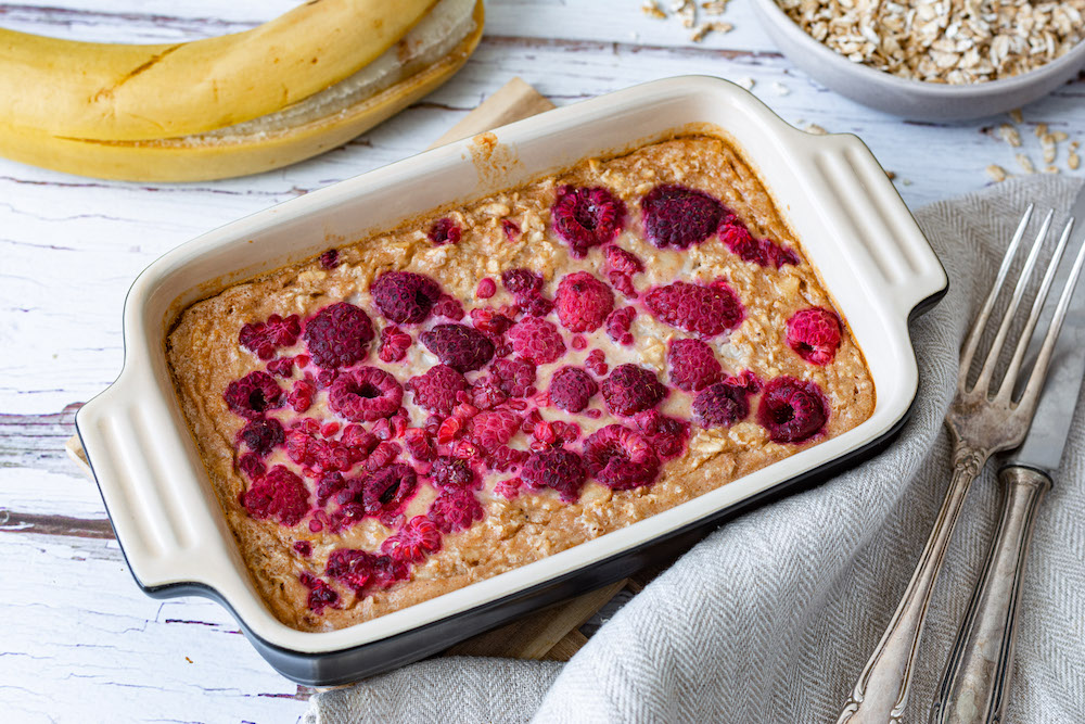 Baked Oats mit Banane und Himbeeren in einer Auflaufform gebacken