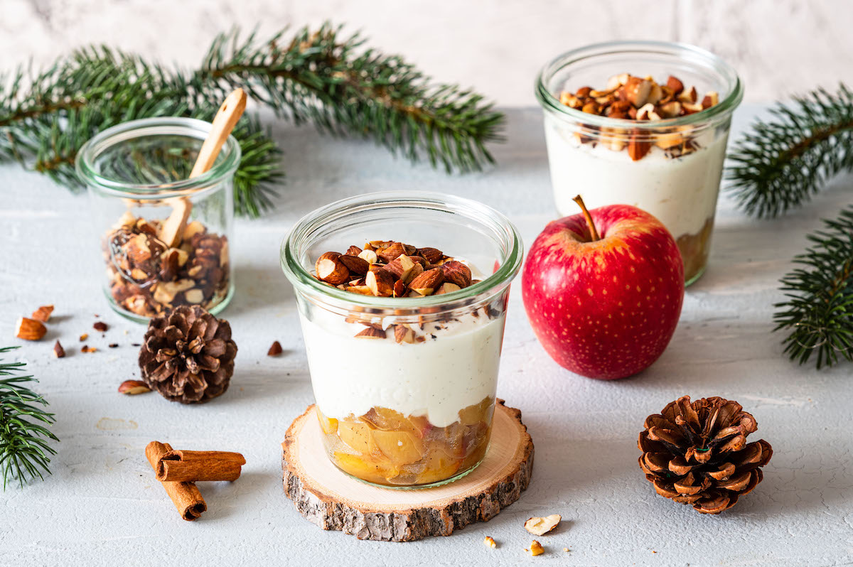 Gesundes Bratapfel-Dessert als Schichtdessert im Glas mit Zimtäpfeln, Quark und gerösteten Nüssen.