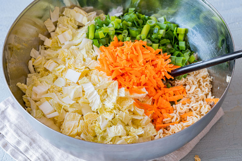 Schüssel mit Instant-Nudeln, Chinakohl, Möhren und Frühlingszwiebeln.