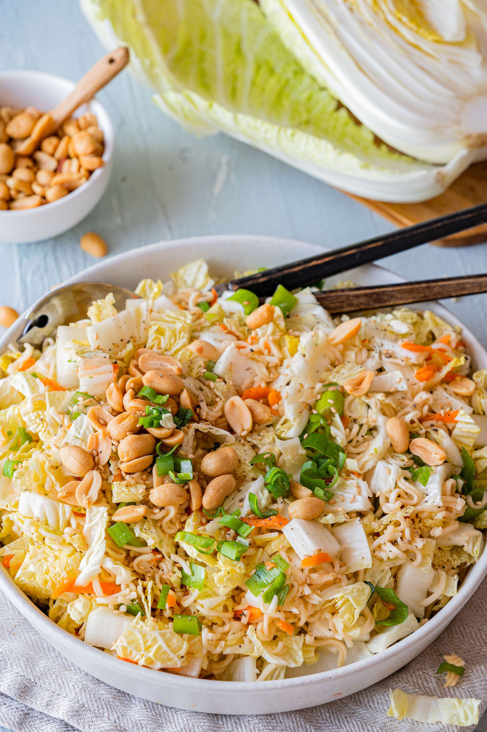 Yum Yum Salat mit Chinakohl, Frühlingszwiebeln und Erdnüssen in einer Schüssel serviert.
