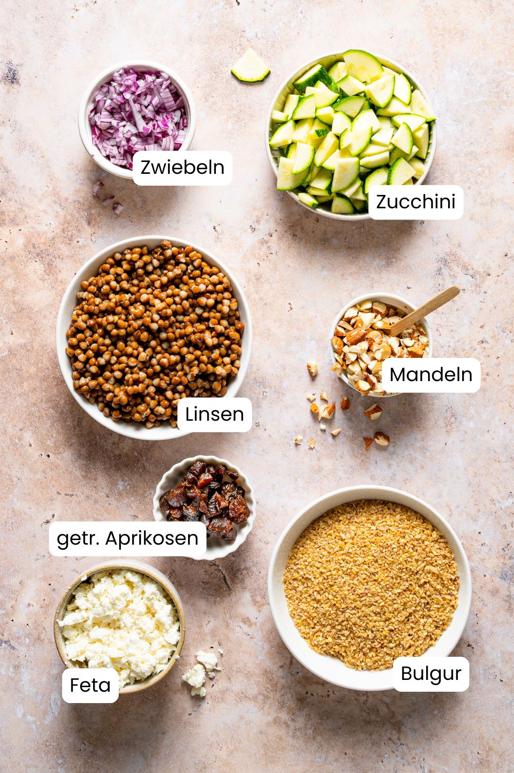 Zutaten für den Bulgur-Linsen-Salat in Schüsselchen fotografiert und als Grafik beschriftet.