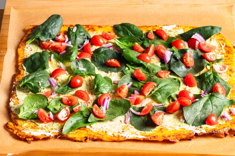 Kürbisrolle belegt mit Spinat und Tomaten.