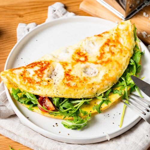 Halloumi-Omelette mit Rucola und Tomaten gefüllt.