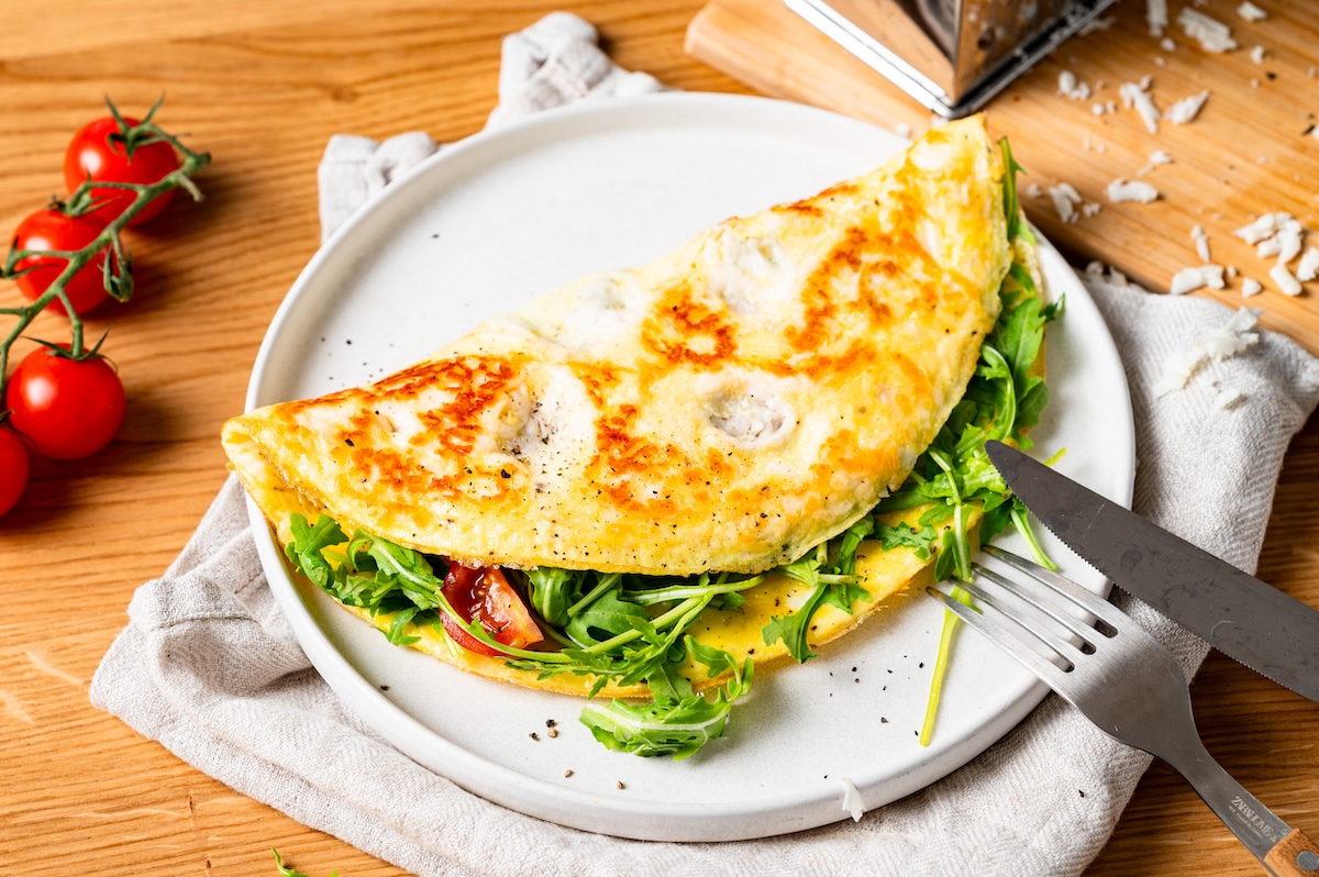 Halloumi-Omelette mit Rucola und Tomaten gefüllt.