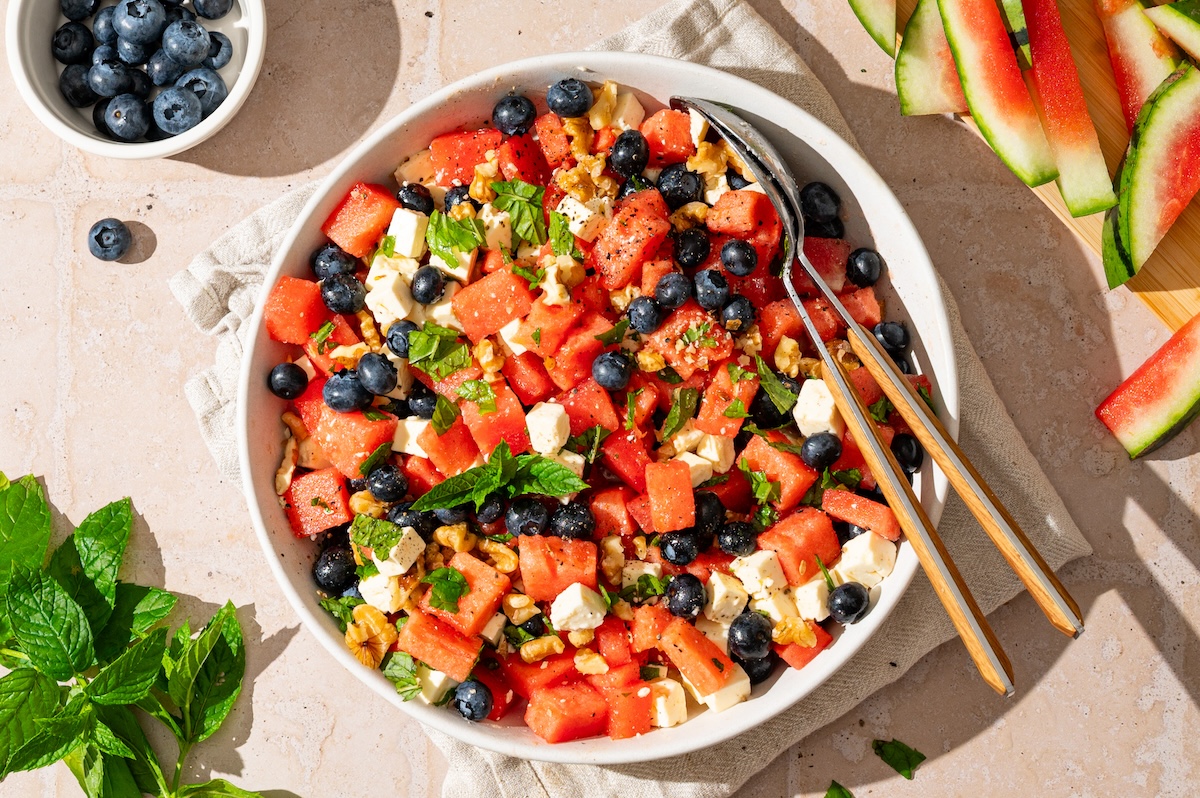 Melonen-Feta-Salat mit Heidelbeeren, Walnüssen und Minze in einer Schüssel.