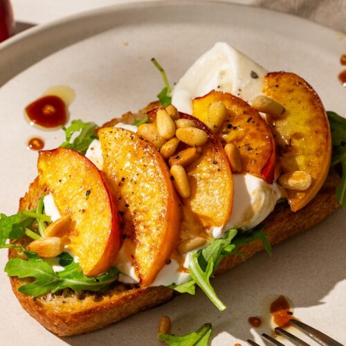 Nektarinen-Burrata-Brot mit Rucola und Pinienkernen.