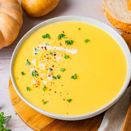 Muskatkürbis-Suppe mit Kartoffeln und Sahne in einer Schüssel serviert.